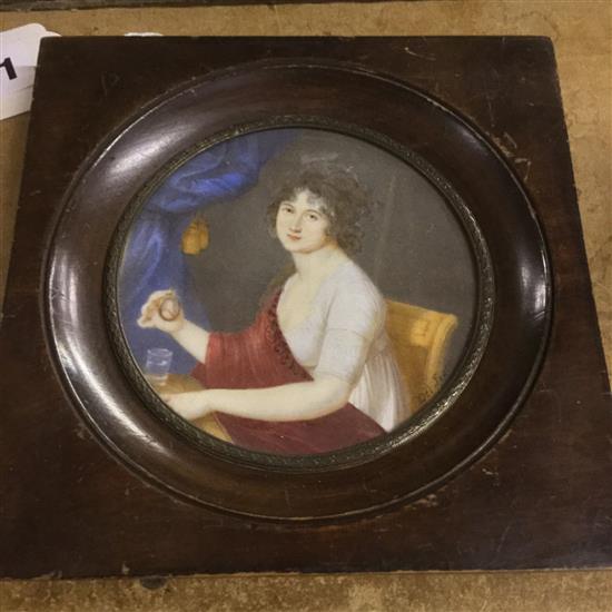 Circular miniature portrait of a young lady, seated holding a portrait miniature, signed Frate